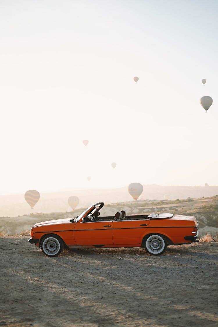 Vintage Car In Landscape With Hot Air Balloons