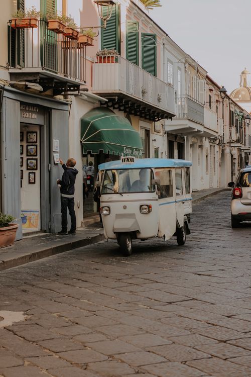 Free A quaint street scene featuring an auto rickshaw in a picturesque old town setting. Stock Photo