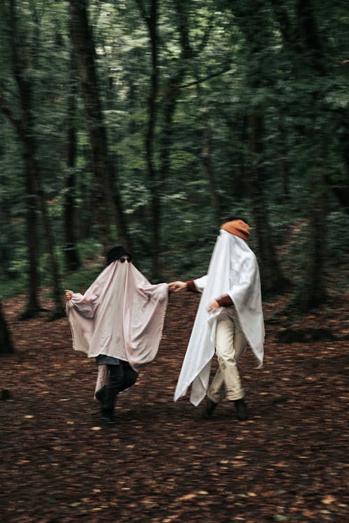 People in Ghost Costumes Dancing in Forest