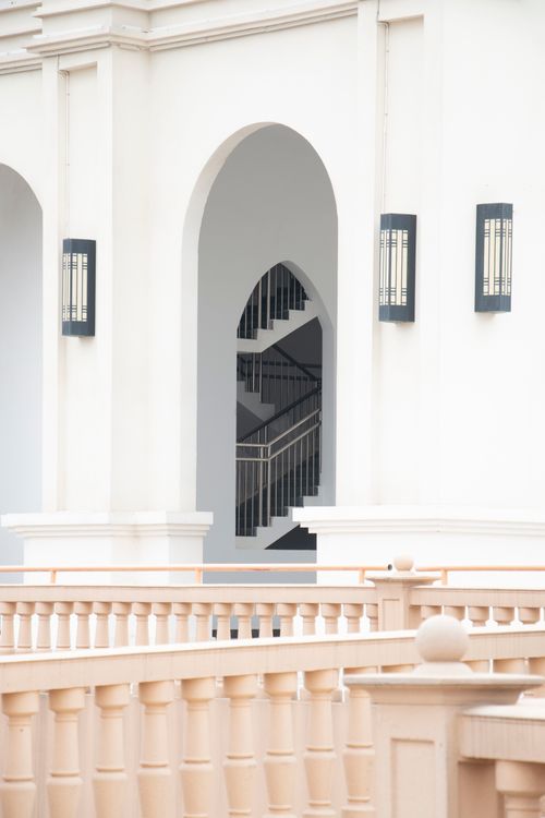Free Minimalist architecture with arches, sconces, and railings in a white building interior. Stock Photo