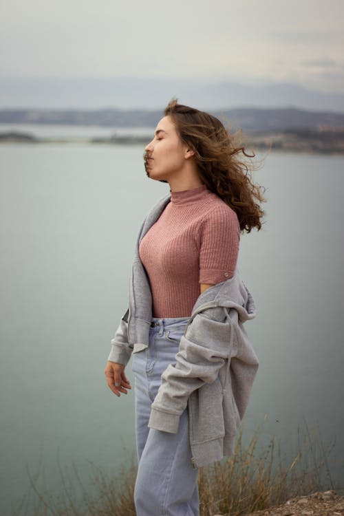 Woman Standing Beside a Mountain Cliff