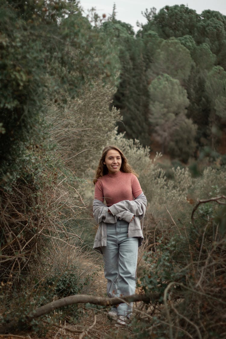 Smiling Woman Standing On Forest Pathway