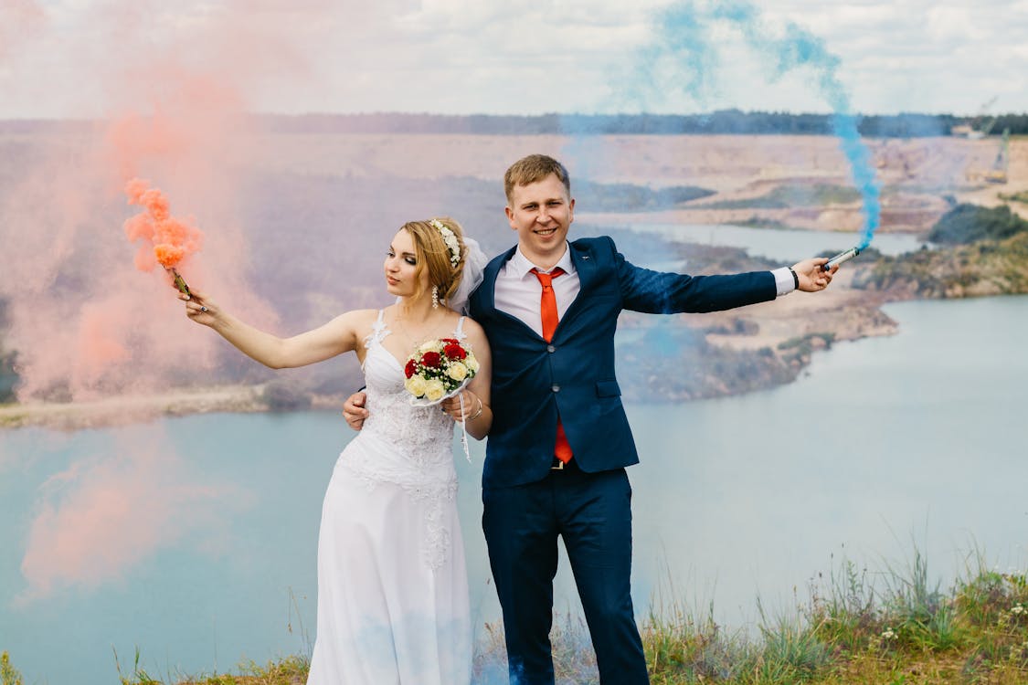 Braut Und Bräutigam Halten Rauchbomben Nahe Dem Gewässer