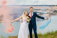 幸福的夫妇在婚礼上用彩色烟雾弹在户外庆祝