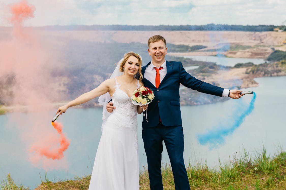 Жених и невеста держат дымовые шашки