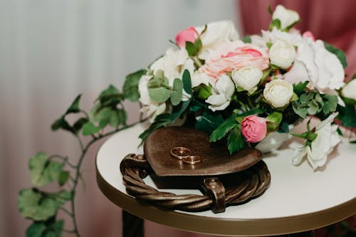 Two Gold Rings Near White And Pink Flowers 