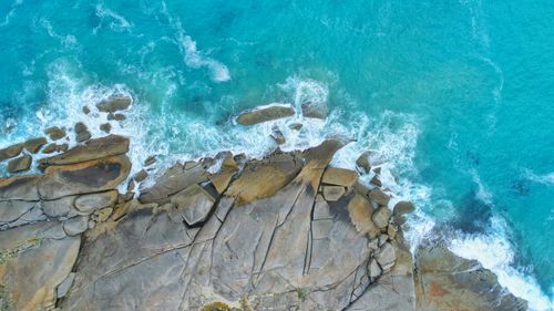 Free Stunning aerial view of Wilsons Promontory's rocky shoreline with turquoise waves crashing. Perfect for nature and travel themes. Stock Photo