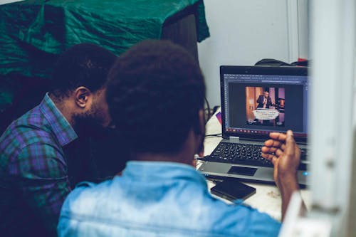 Two Man Sitting on Chair in Front of Laptop Computer