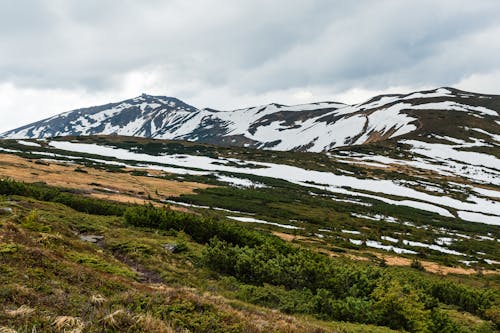 Snow Covered Mountain Under Cloudy Sky