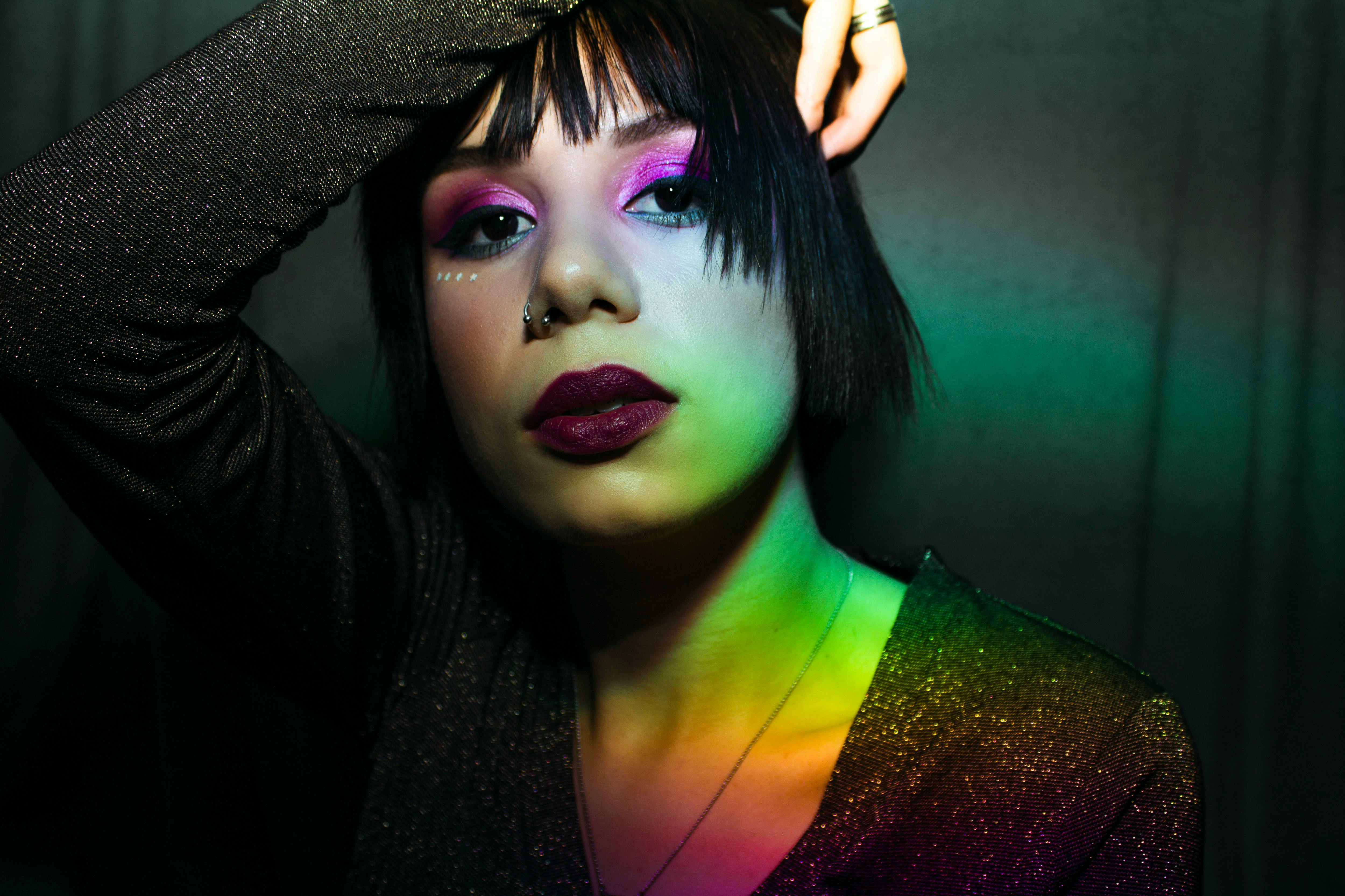 一幅女性肖像，以大胆的妆容和引人注目的灯光，展现出自信与优雅