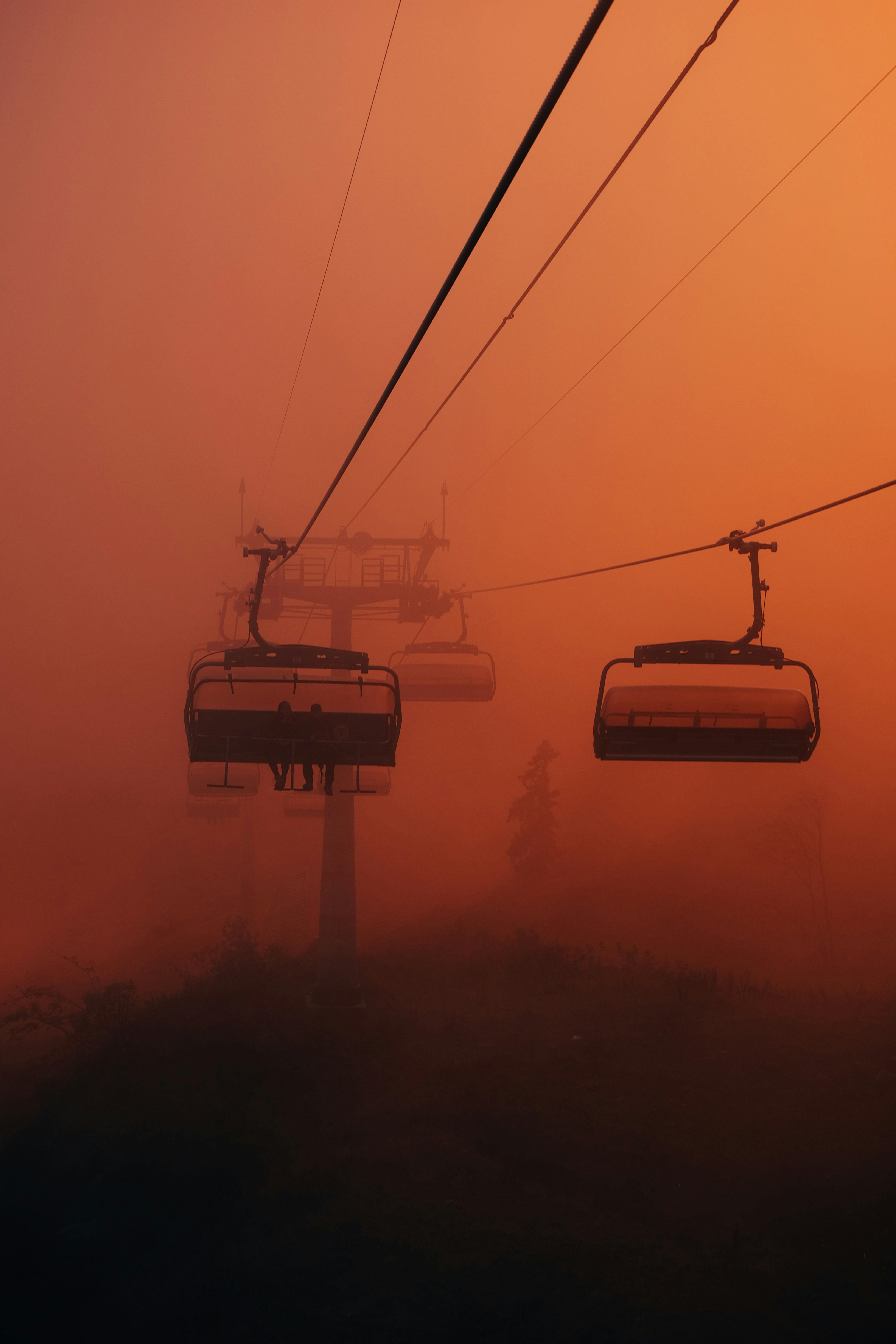 Prescription Goggle Inserts - Dramatic silhouette of a chairlift against a vibrant sunset sky during winter.