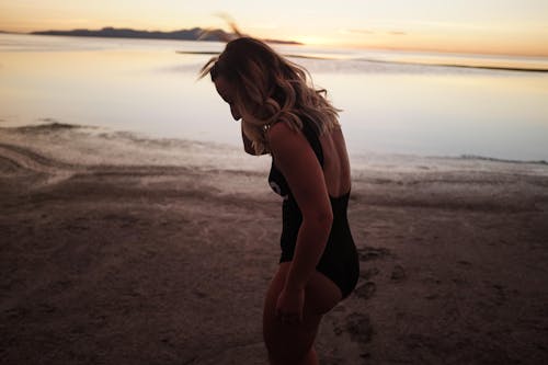 Donna Che Indossa Un Bikini Nero Di Un Pezzo In Piedi Sulla Riva Vicino Alla Spiaggia Durante Il Tramonto