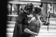 一张黑白图像中，一对夫妇在城市户外分享亲密时刻