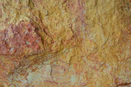 Free Detailed close-up of a rough and colorful rock surface with natural texture. Stock Photo