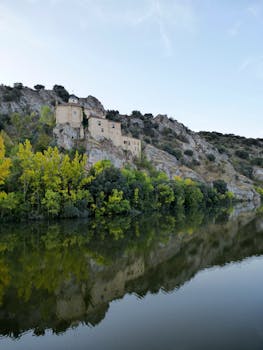 Picturesque view of Hermitage of San Saturio on a hillside reflecting in the Douro River, Soria, Spain.