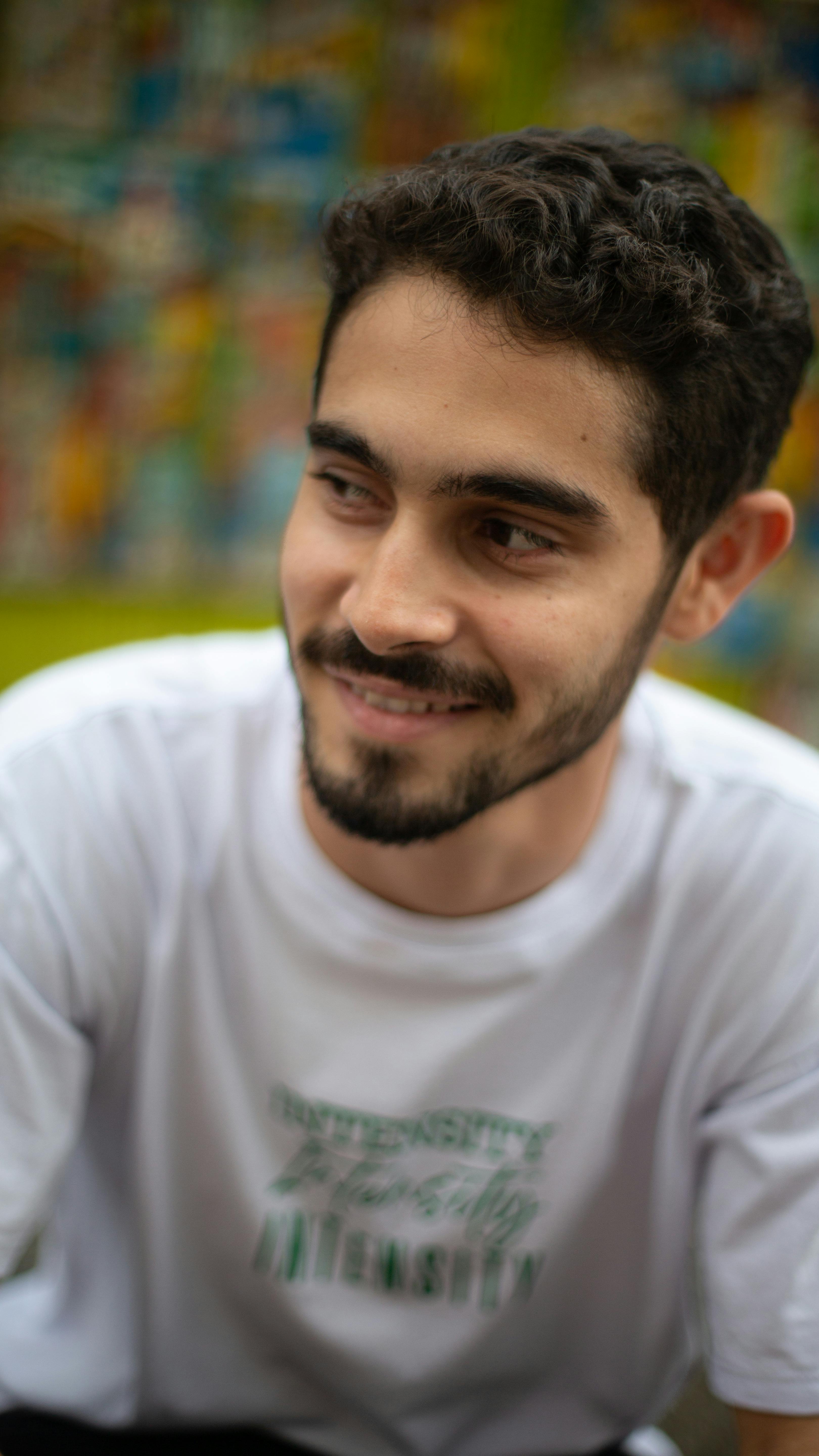 Happy young man with facial hair smiling outdoors in Salvador, BA, Brazil.