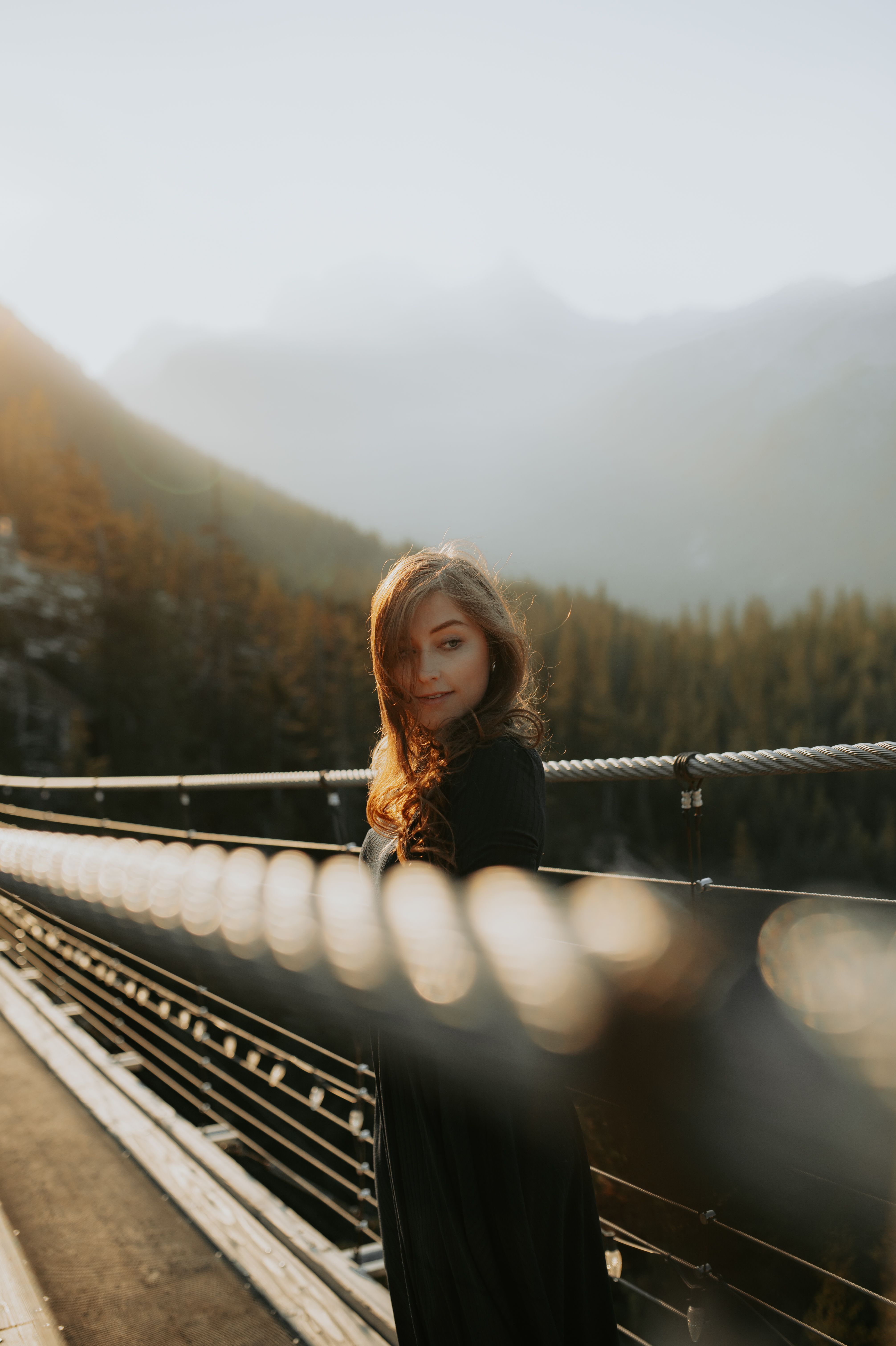 Woman in Black Coat Standing on a Bridge · Free Stock Photo