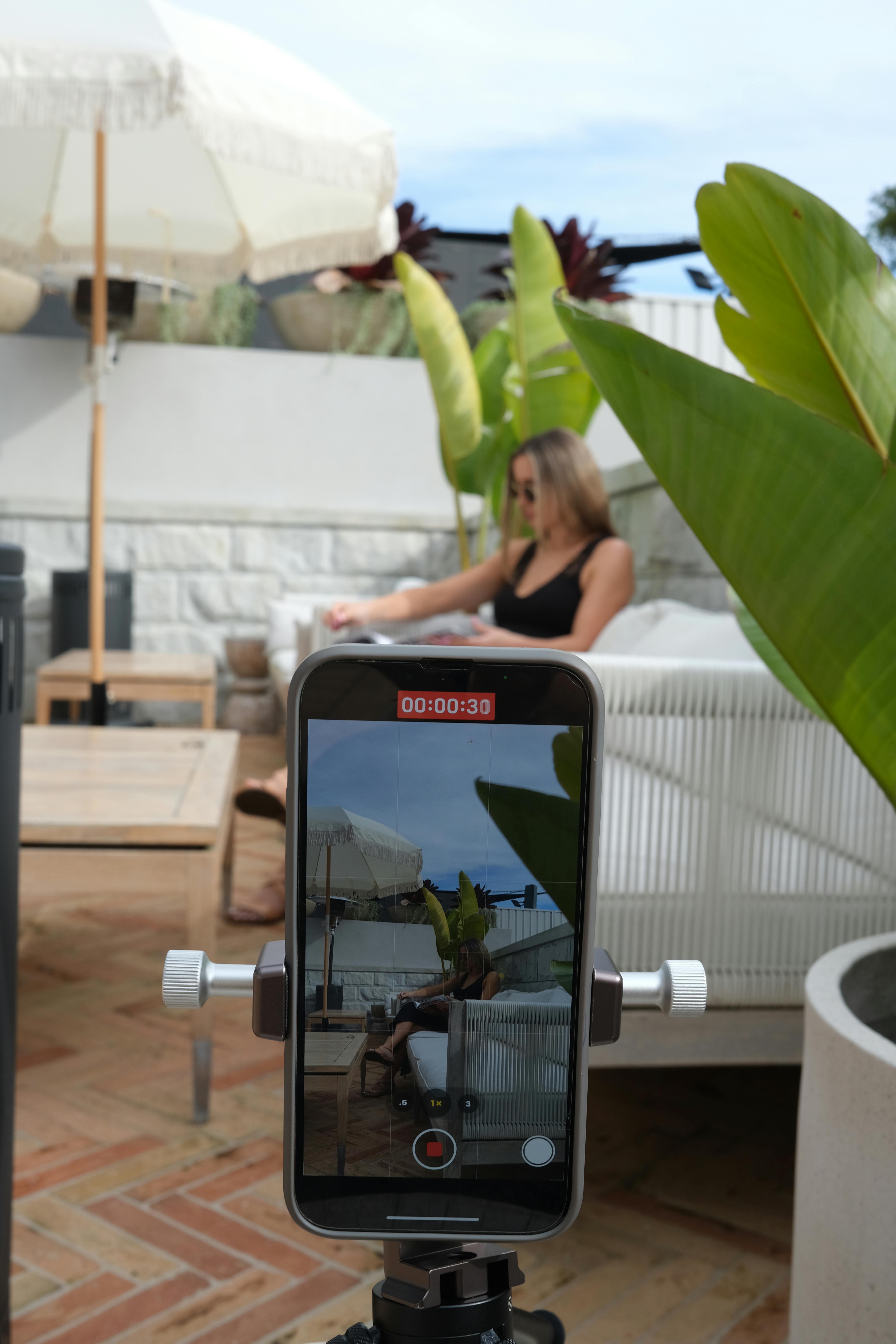 blonde in patio being recorded with smartphone