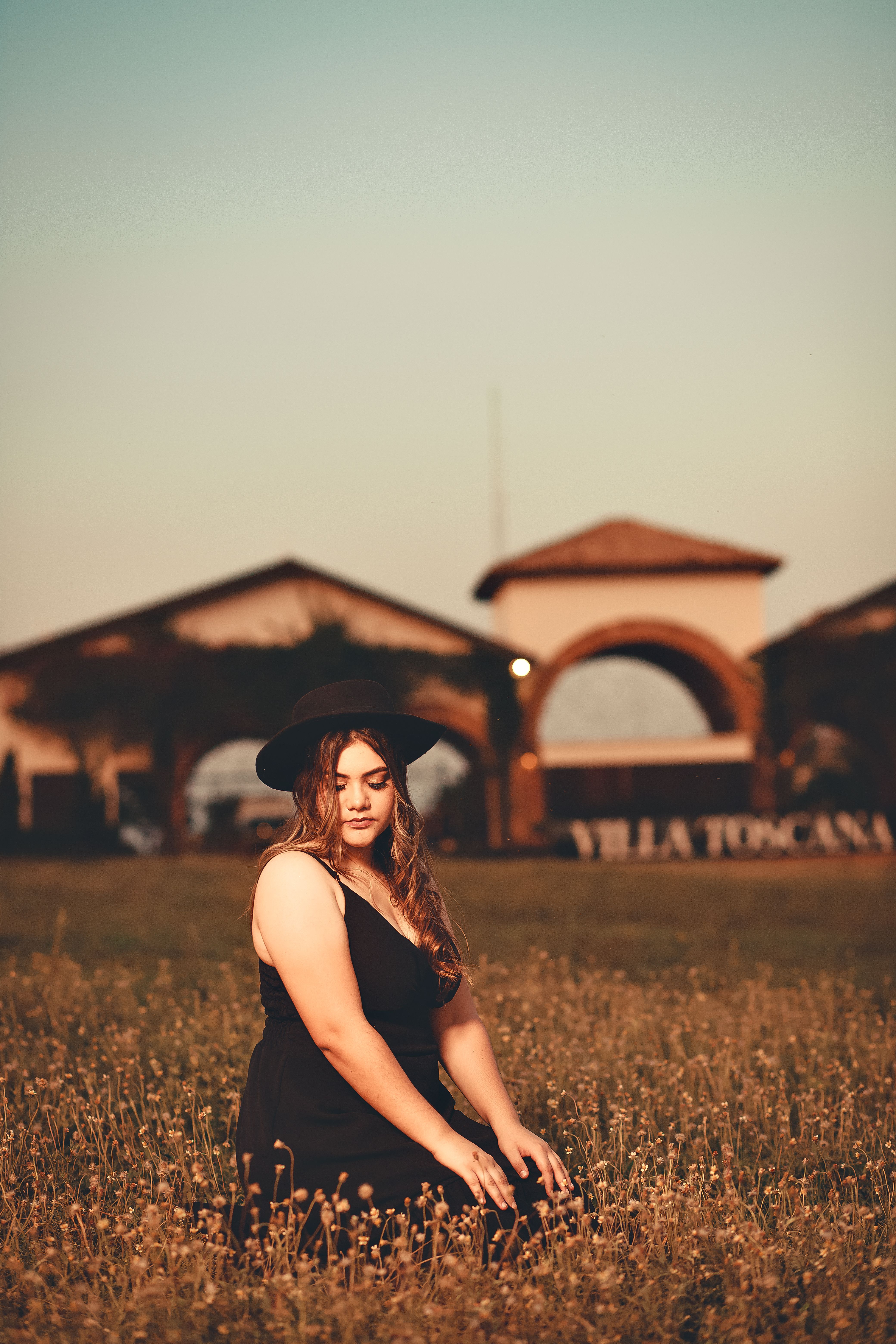 Woman in Black Dress and Black Hat Sitting on Grass Field · Free Stock ...