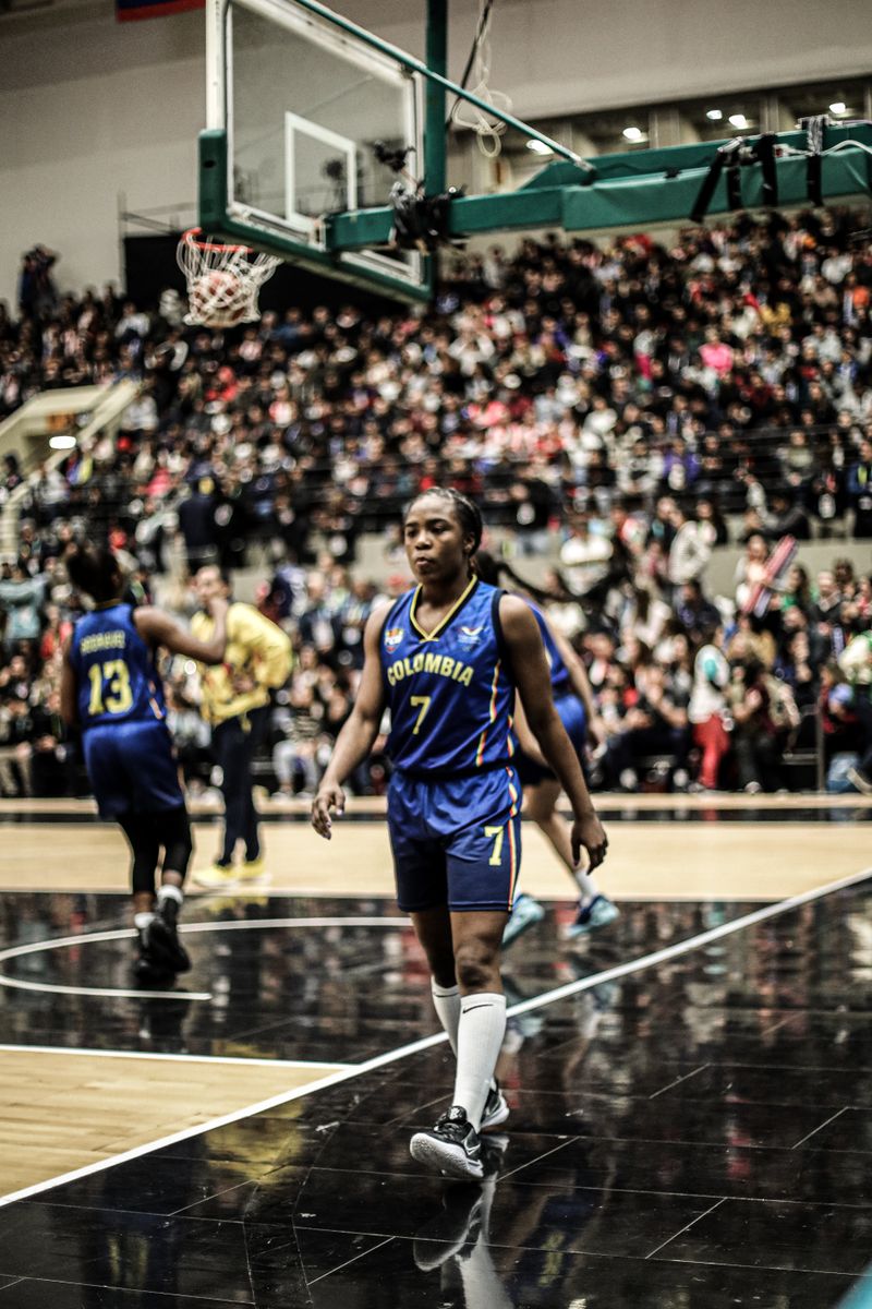 Basketball athlete walking on court during a game in an indoor arena.