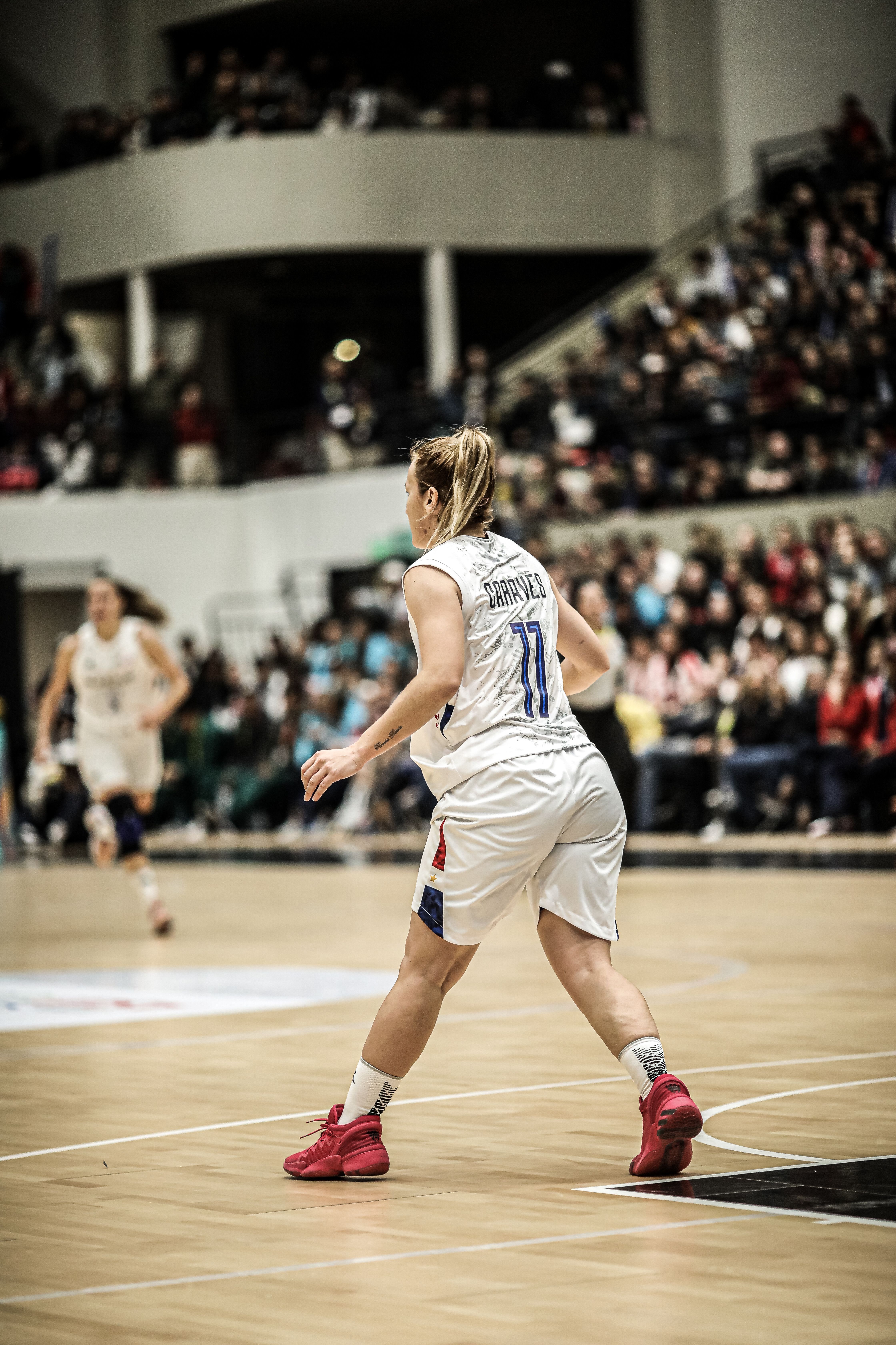 Intense action shot of a women’s basketball game with players in motion on the court.