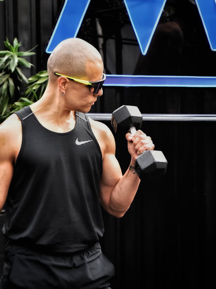 A Man In Sunglasses Using A Dumbbell