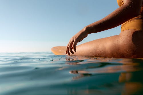 Low Angle Shot of a Woman Wearing a Yellow Swimsuit Bathing in the Sea Water