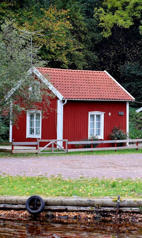 Red Wooden House Near Green Trees