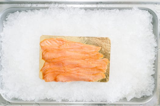 Thinly sliced smoked salmon placed elegantly on ice in a close-up shot.