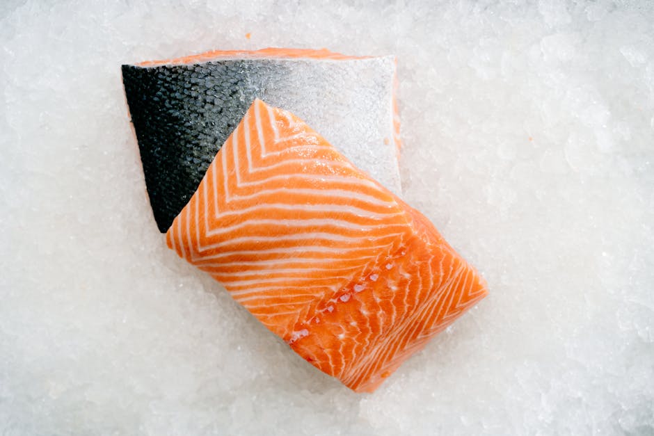 Close-up of a fresh raw salmon fillet on ice, showcasing vibrant colors and freshness.