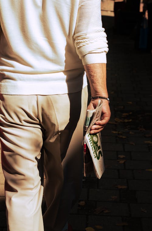 Man in White Long Sleeves Holding a Newspaper 