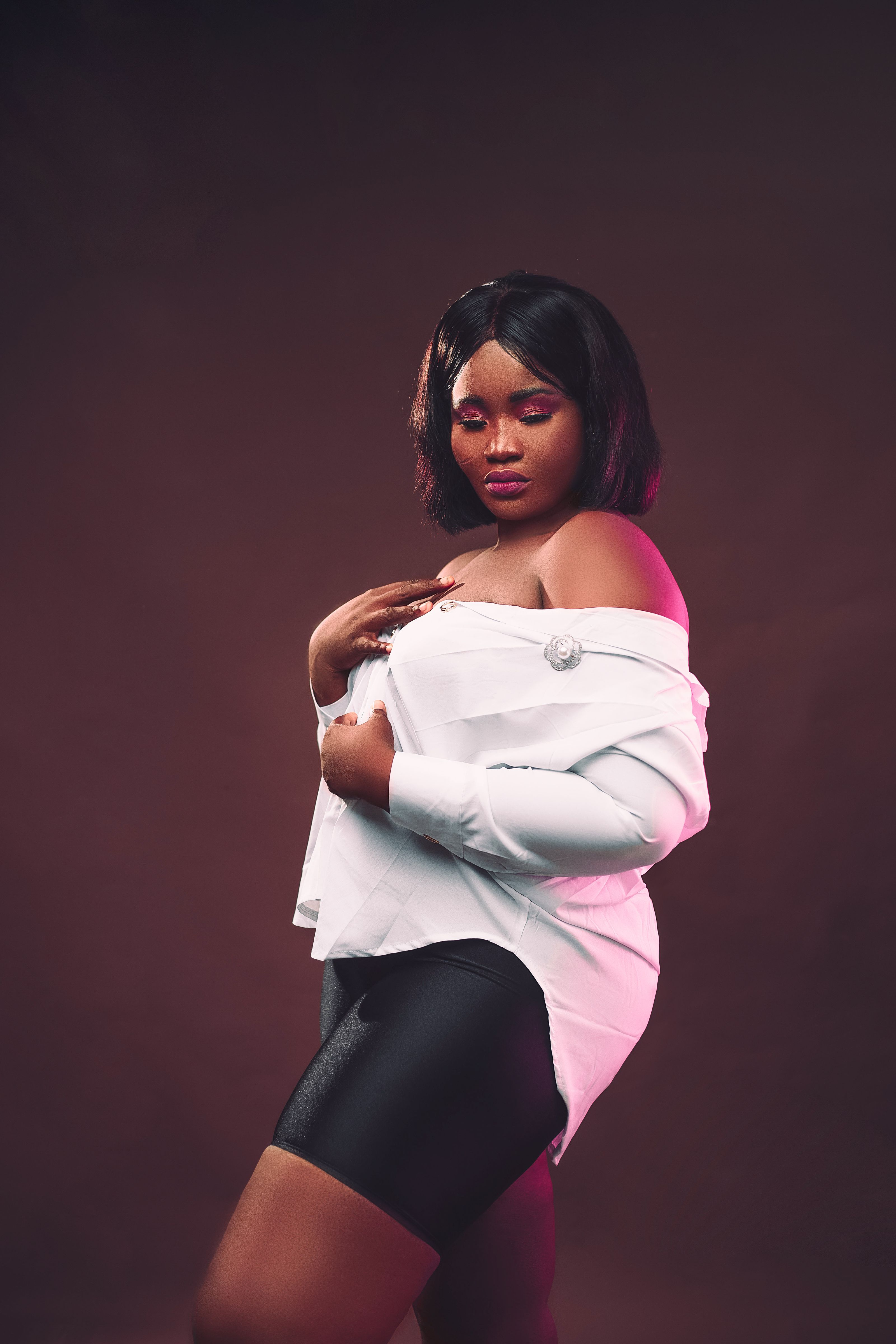 Retrato estiloso de uma mulher negra confiante em uma blusa branca off shoulder.