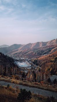 A stunning view of Medeu Ice Rink nestled in the autumnal mountains of Almaty, Kazakhstan.