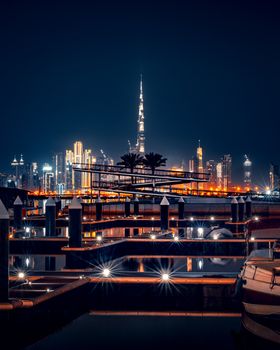 Stunning nighttime cityscape showcasing the illuminated Dubai Marina and Burj Khalifa.