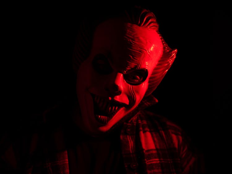 A Person Wearing Scary Mask In A Dark Room