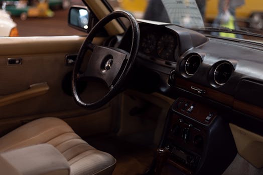 Explore the classic design of a vintage Mercedes interior showcasing a retro dashboard and steering wheel.