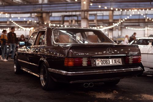 Free Captivating rear view of a vintage Mercedes 280 SE with AMG branding at an indoor car exhibition. Stock Photo