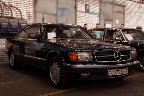 Free Black Mercedes Benz Coupe Parked Beside a Brick Wall Stock Photo