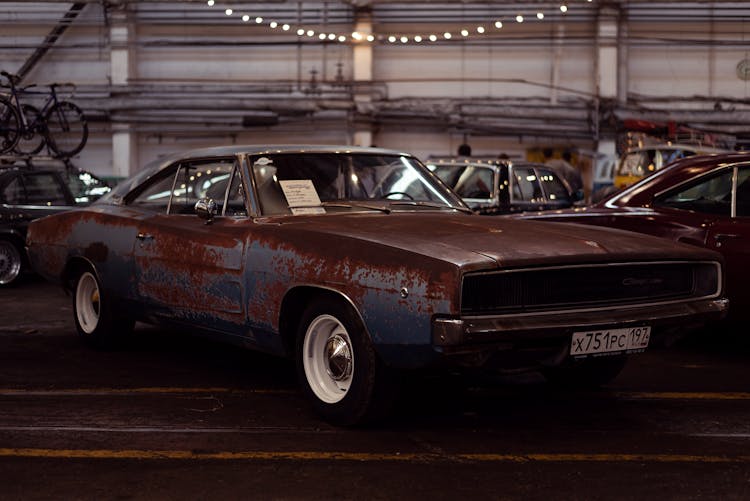 Rusty Muscle Car Parked At A Parking Garage