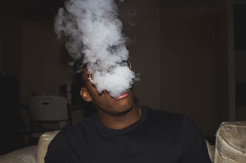 Man Wearing Black Crew-neck Blowing Smoke