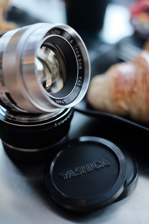 Free Detailed shot of a vintage Yashica camera lens with a blurred background. Stock Photo