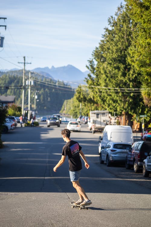 Základová fotografie zdarma na téma auta, chlapec, jízda na skateboardu