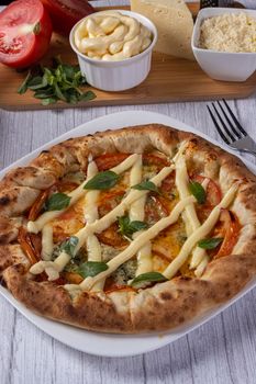 Delicious gourmet pizza topped with cheese and fresh basil leaves on a rustic table.