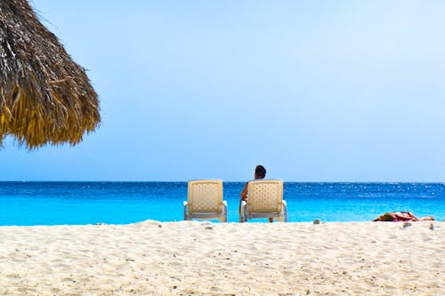 Free Person Sitting On Lounge Chair At The Beach Stock Photo
