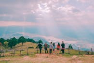 一群朋友欣赏着阳光穿透云层的秀丽山景