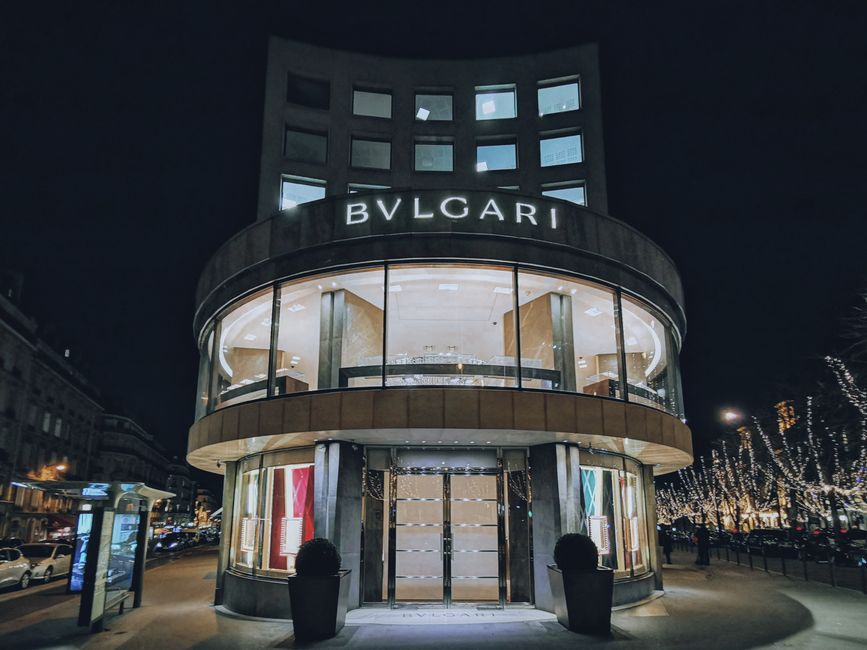 A Cheongdam luxury flagship avenue at dusk with marble facades and low-lit boutiques