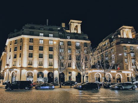 Night view of the illuminated Four Seasons Hotel George V, Paris with nearby traffic.