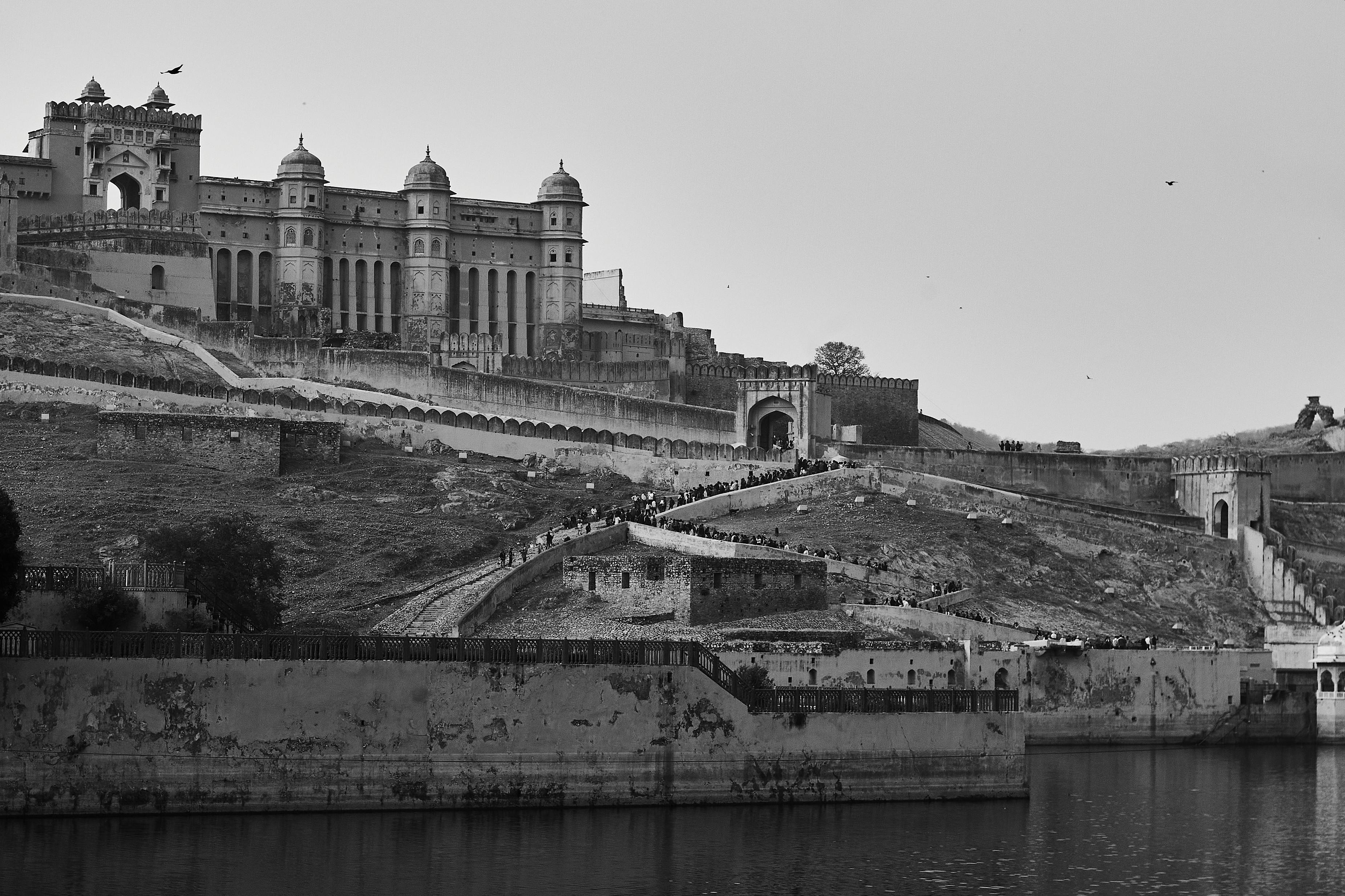 Black and white view of the Amber Fort in Rajasthan, showcasing its architectural grandeur. - Amberes
