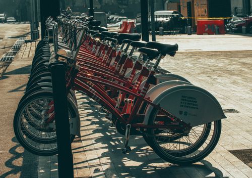 Free Lined up red rental bicycles on a sunny street in Ciudad de México, perfect for urban commuting imagery. Stock Photo