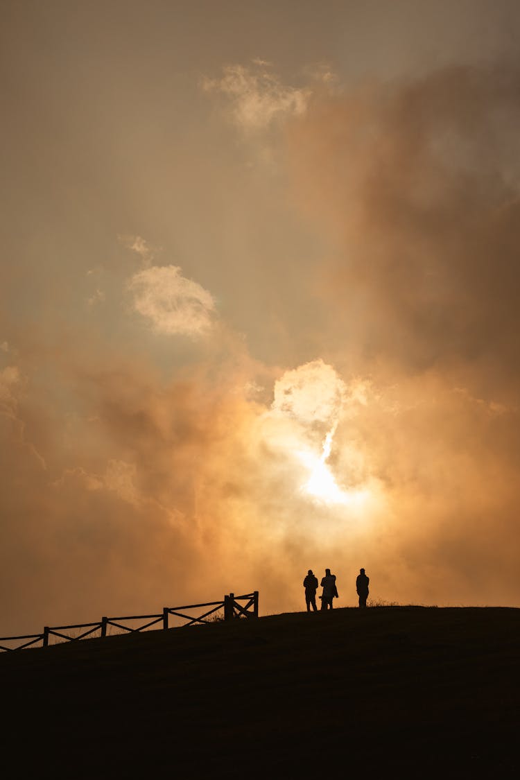 Silhouette Of People Standing On Hill Top